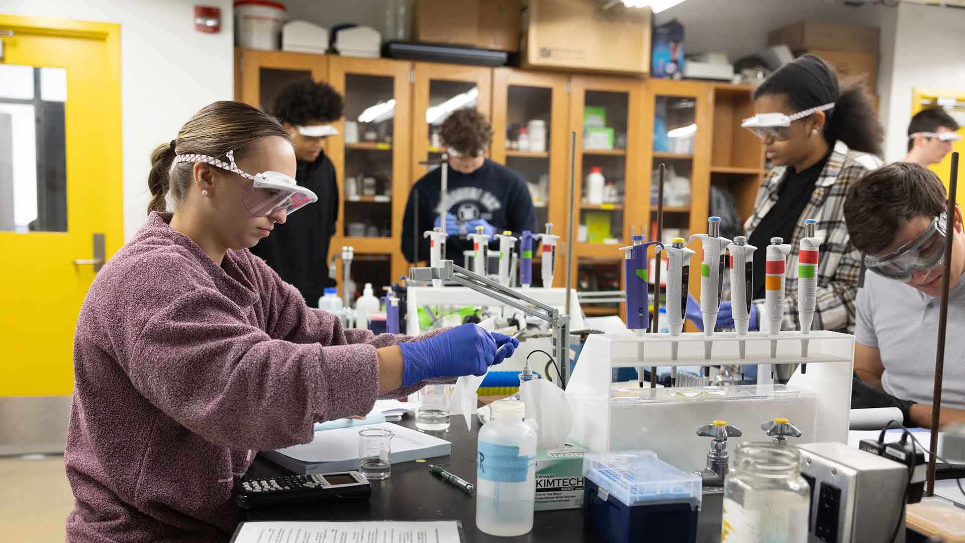 Chemistry students using equipment during a lab class.