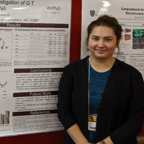 Megan Westwood poses next to her research poster at a conference
