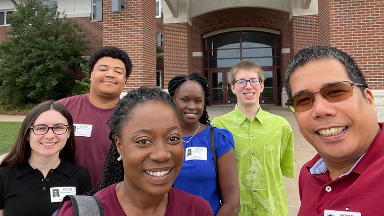 Chemistry students and professor take a group selfie while visiting a local high school to promote the program.